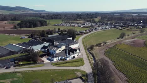 Aerial-view-of-Fettercairn-whisky-distillery-on-a-sunny-spring-day,-Aberdeenshire,-Scotland