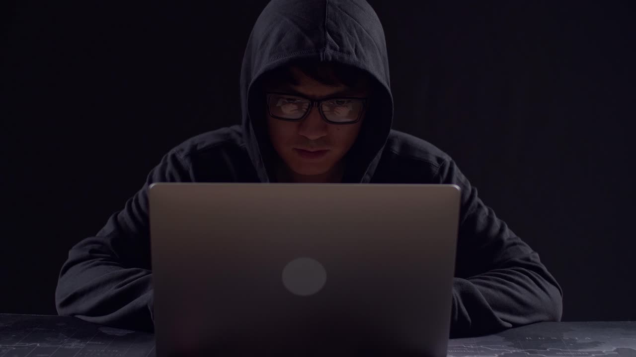 Asian Male Hacker Using Laptop Computer Hacking