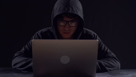 asian male hacker using laptop computer hacking