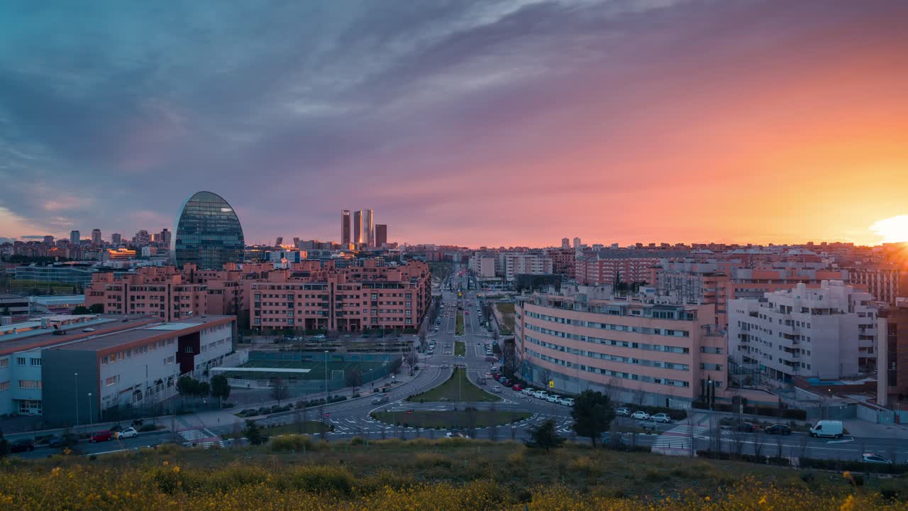 현대 유럽 도시 마드리드의 스카이 라스 타블라스 전망대에서 해가 지는 동안 황금빛과 빨간 구름과 함께 블루 아워 동안 낮에서 밤으로 확대 시간 스 노란색 꽃 전면