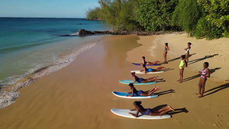 girls learning to surf on a tropical beach