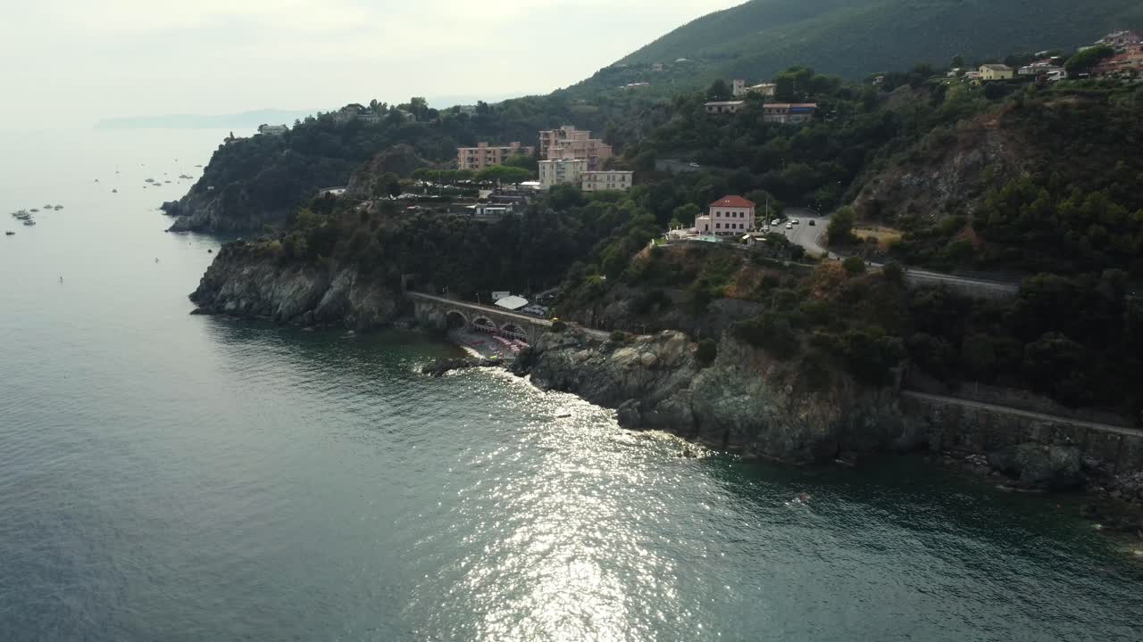 Paesaggio costiero con edifici e montagne
