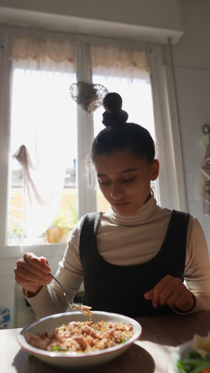 una mujer joven comiendo una comida en una cocina