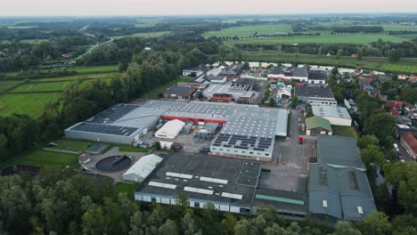 Aerial-overview-of-small-industrial-site-with-photovoltaic-solar-panels-on-rooftop-and-a-small-water-treatment-basin