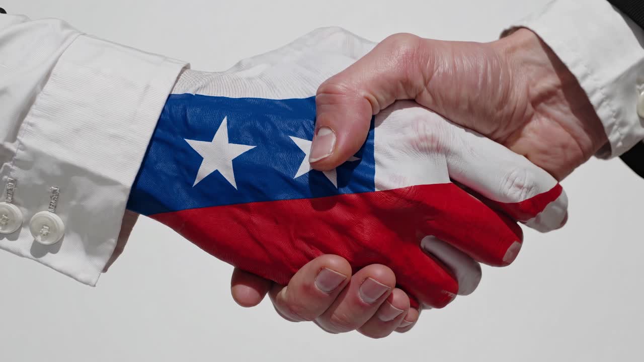 Business professionals networking, displaying national pride, hands clasping with Chilean flag painted on skin during collaborative meeting in minimalist white studio setting