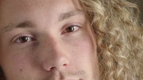 close up portrait of pensive young man eyes turns head looking at camera serious contemplative