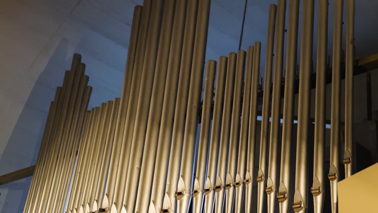 Pan up to organ tubes in the church