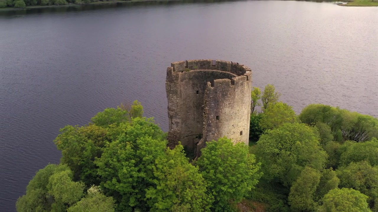 Rekaman udara dinamis Kastil Cloughoughter yang bersejarah pada malam yang tenang, County Cavan Irlandia