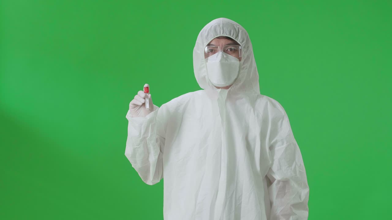 Asian Man Wearing Personal Protective Equipment Uniform Ppe, Medical Face Mask And Holding A Glass Of Test Tube In The Green Screen Studio