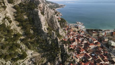 Aerial-view-town-of-Omiš-surrounded-by-Alpine-mountains-and-Adriatic-Sea