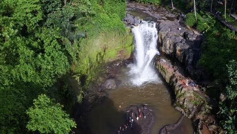 Vista-Aérea-De-Turistas-De-Pie-Junto-A-La-Cascada-De-Tegenungan-En-Bali,-Indonesia