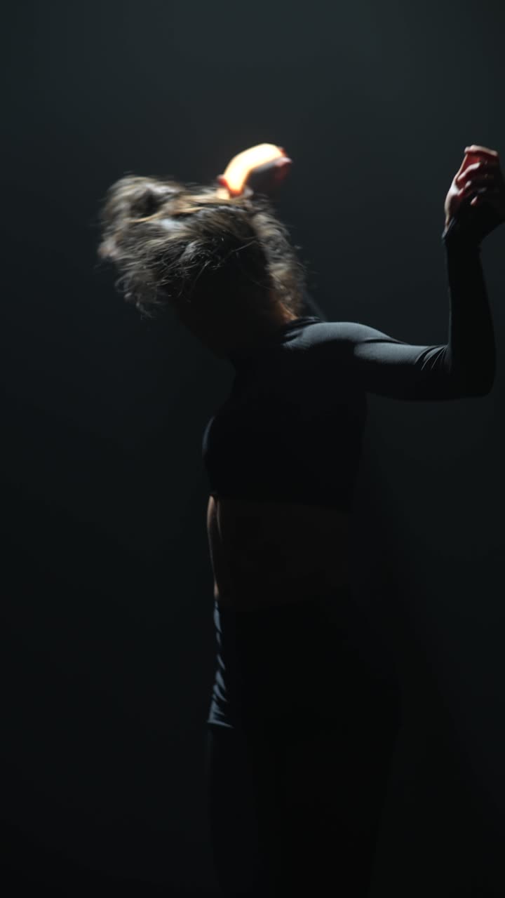 Female Dancer Performing Fire Poi in Dark Setting