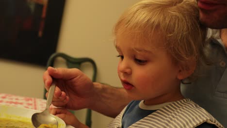 padre alimentando al bebé en casa en 4k. padre nutriendo al niño pequeño
