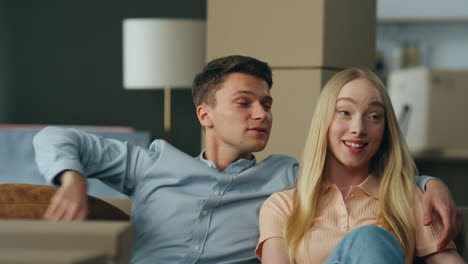 couple discussing interior new apartment sitting at couch close up. pair moving.