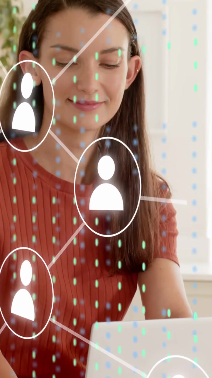 Vertical video: Woman typing and sipping water, icons forming net dots over laptop screen for tech
