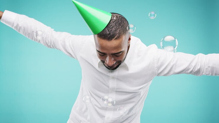 Crazy face mixed race man dancing with bubbles slow motion photo booth blue background