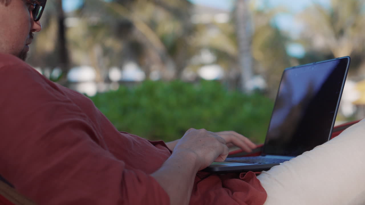 hombre trabajando en una computadora portátil en la playa