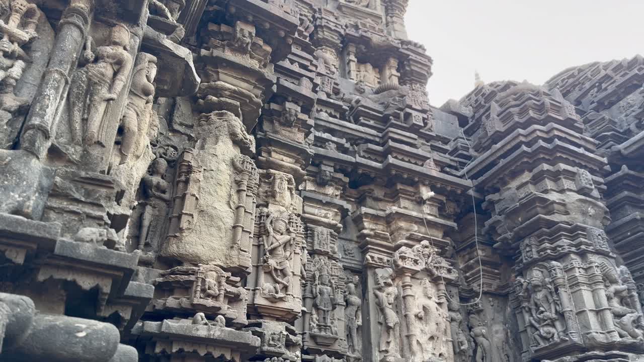 Ambernath temple's stone wall features intricate carvings of deities and figures