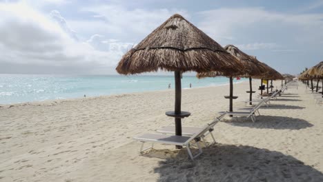 Eine-Reihe-Von-Strandbetten-Und-Sonnenschirmen-Am-Meer