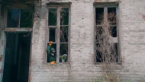 man with gas mask in destroyed building. man wearing protective suit and mask against radioactive environment