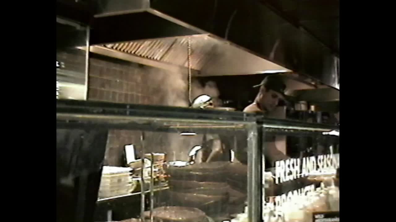 Busy open kitchen with steam and stacked dishes