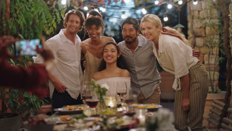 amigos de la fiesta de cena posando para una foto celebrando la amistad disfrutando de la reunión reuniéndose haciendo recuerdos en la noche de verano al aire libre