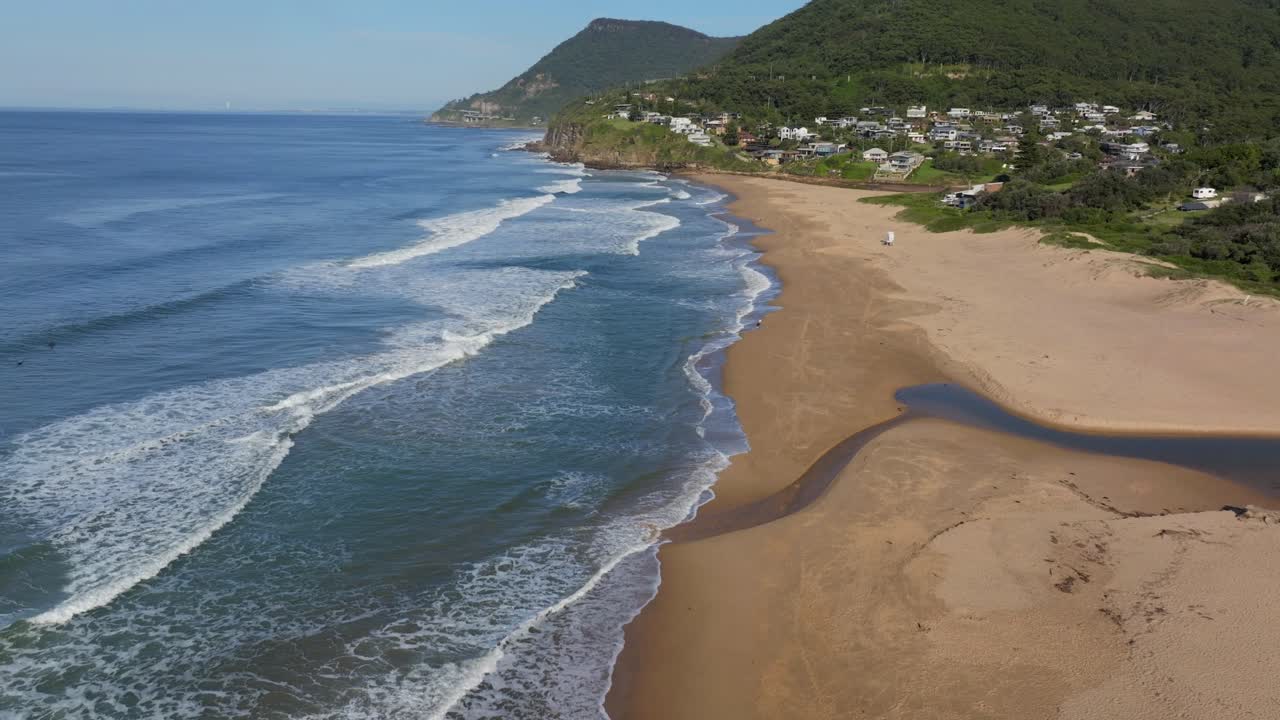 stanwell park beach avión no tripulado cielo azul soleado mañana de día arroyo salvavidas torre wollongong nsw australia sydney costa sur illawarra coal cliff throull tren hacia adelante pan arriba lentamente