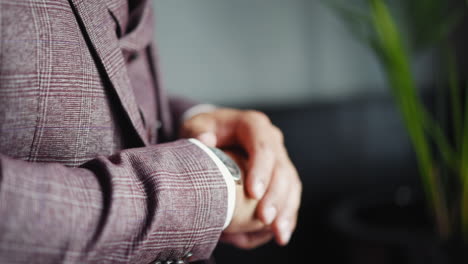 Un-Hombre-De-Negocios-Con-Traje-Comprueba-El-Tiempo-Mirando-El-Reloj-De-Pulsera.