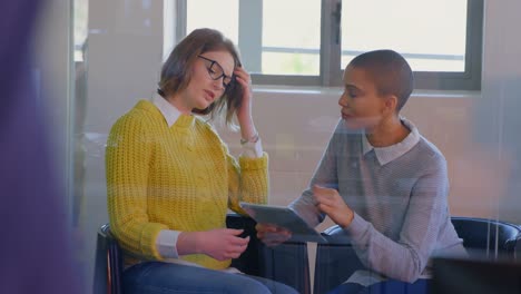 Junge-Kaukasische-Weibliche-Führungskräfte-Diskutieren-über-Ein-Digitales-Tablet-In-Einem-Modernen-Büro-In-4K