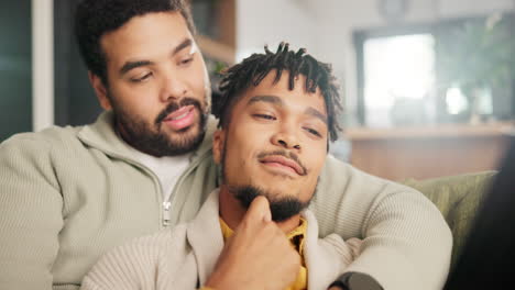 two men relaxing on a sofa