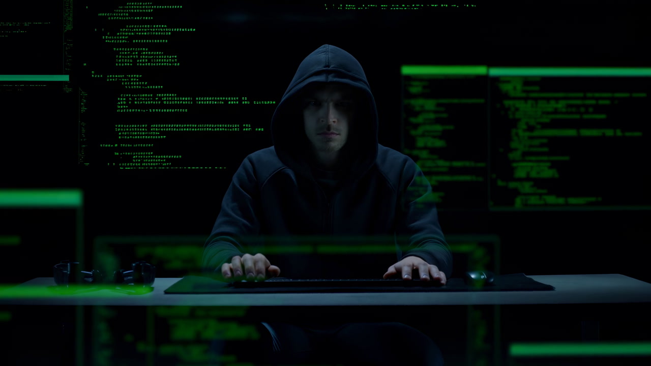 Hooded Hacker At Computer Screen, Green Code Overlays, Latenight Dark Room, Hands Typing On Keyboard, Monitors