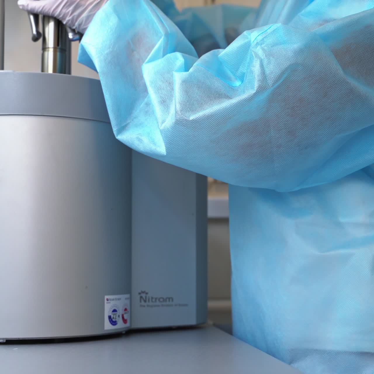 Dentistry tools are being placed on the part of the sterilizing machine. Medical worker puts the instruments into a sterilizer