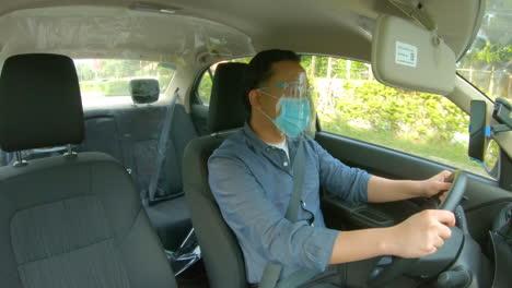 Indoor-Shot-Of-A-Vehicle-With-Plastic-Barrier-And-Driver-With-Face-Mask