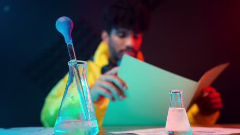 scientist reading report after laboratory test studying analysis data sitting in lab desktop with professional equipment chemical pipette sterilised tubes in foreground