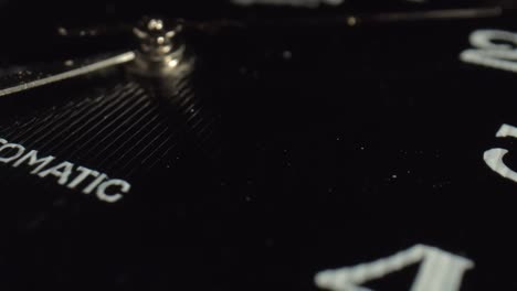 wall clocks with a logo are made according to an individual project. the black corrugated surface of the dial reflects the falling light. close-up.