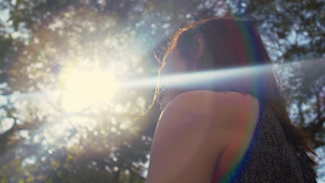 Young-attractive-woman-enjoying-warm-spring-sun-outdoors,-low-angle-medium-shot