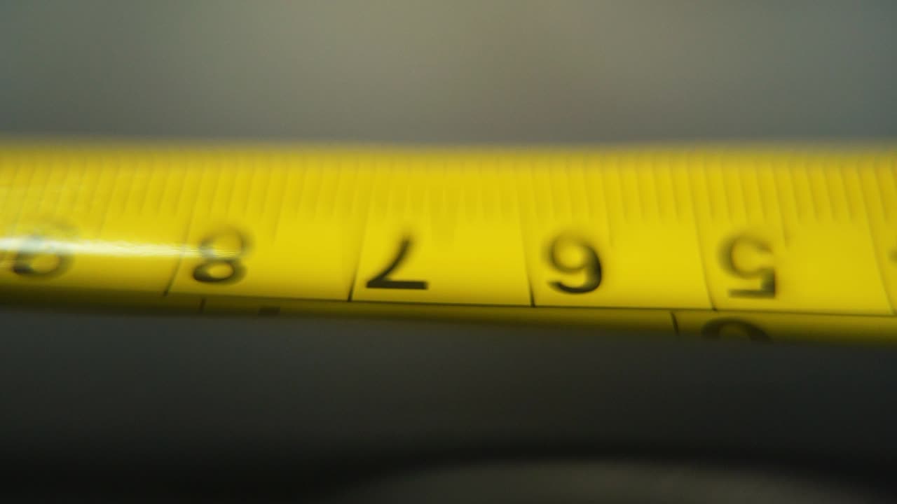 video macro de un medidor amarillo, herramienta de medición, súper primer plano, cámara lenta 120 fps, full hd, movimiento de grúa inclinado hacia arriba