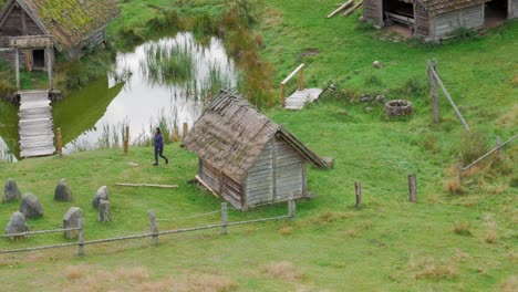 couple hiking on the green landscape with old wooden houses in piaszno, pomeranian voivodeship, poland - high angle shot