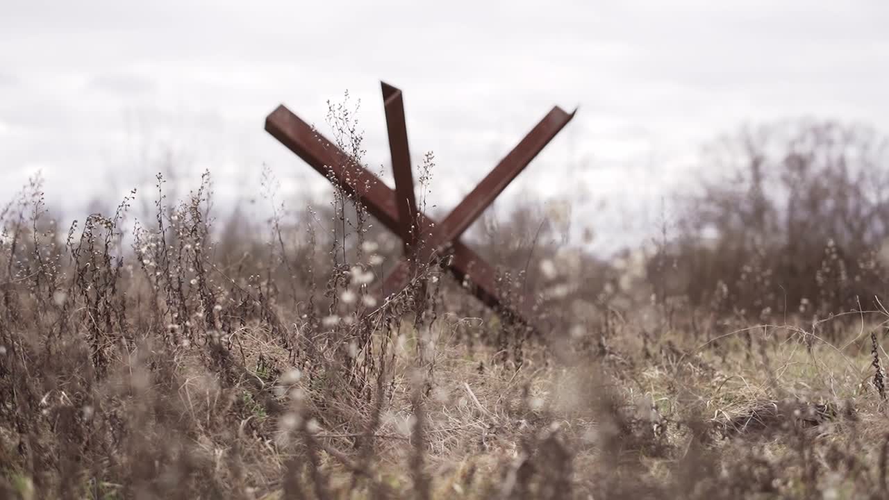 하늘을 반대하는 초원에서 녹색 오래된 전차 방어 장벽