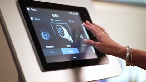 a person uses a touchscreen interface to select monitoring and customization features in a contemporary setting. this interaction showcases advancements in smart technology and user experience.