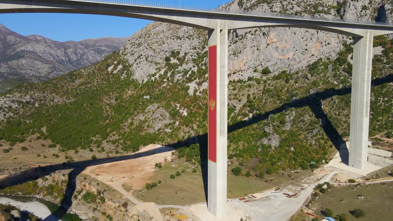 Ripresa aerea del ponte Moracica completamente ultimato in Montenegro. Il grande stemma rosso del Montenegro è visibile su uno dei pilastri del ponte