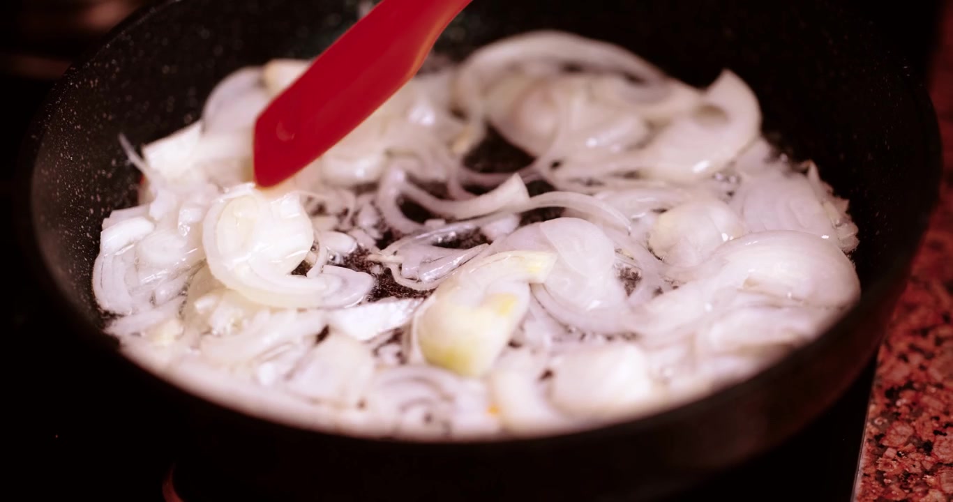 Refogando cebolas numa panela para preparação culinária