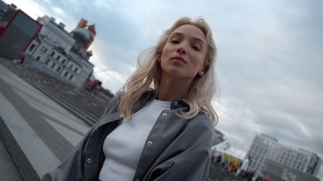 модная девушка позирует городской пейзаж на вечерней улице в центре города.