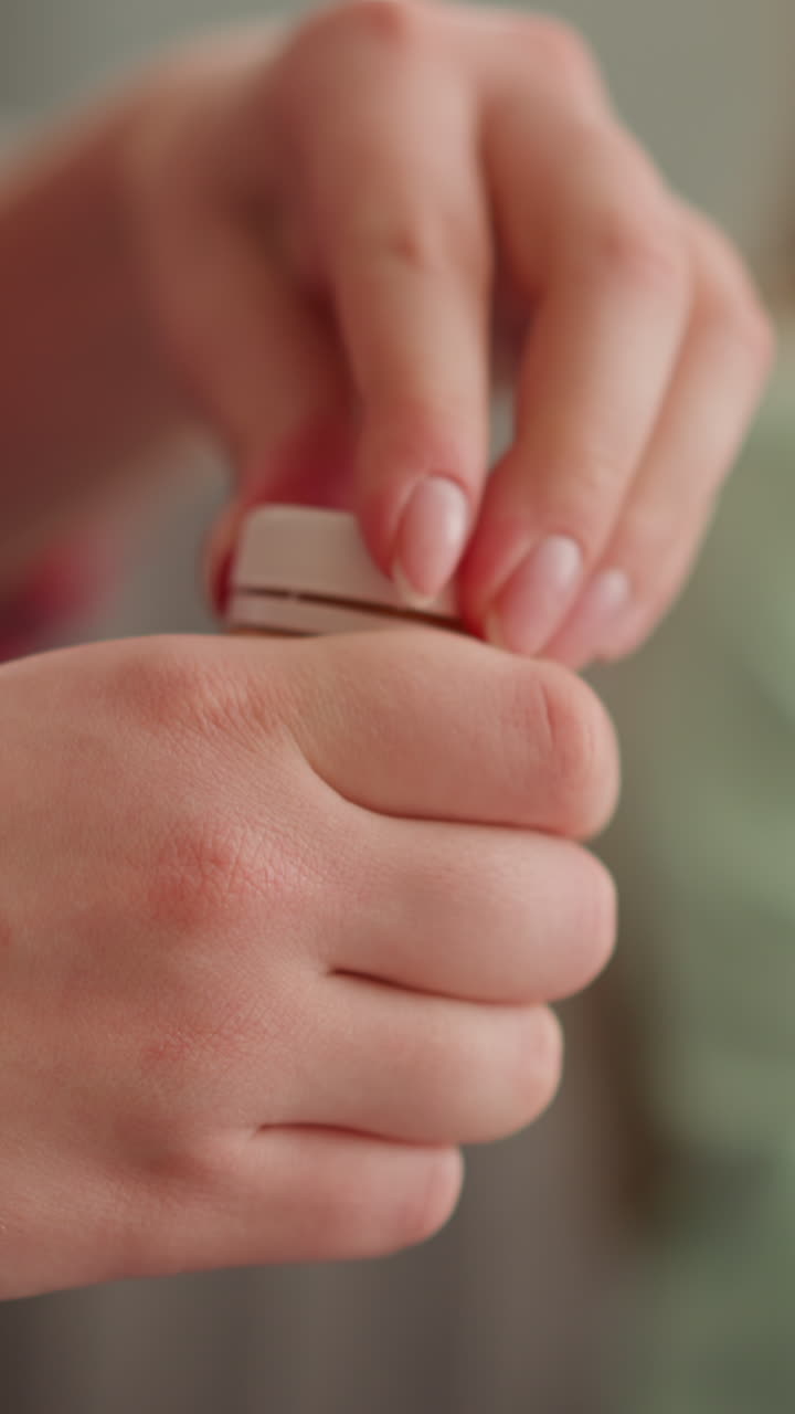 молодая женщина поворачивает крышку, чтобы открыть бутылку с золотой краской, в то время как маленькая девочка сидит рядом в медленном движении. подготовка к уроку искусства. принадлежности для художественной работы