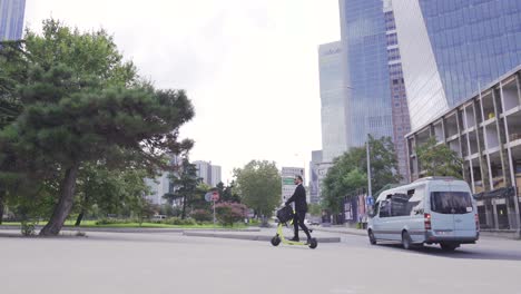 handsome caucasian businessman riding electric scooter near modern building.