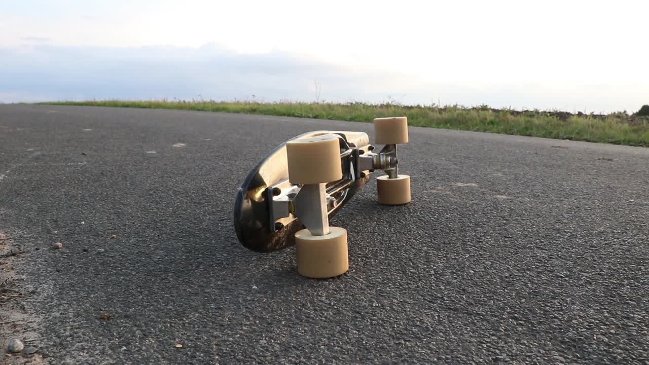 Black pennyboard tilted on asphalt.