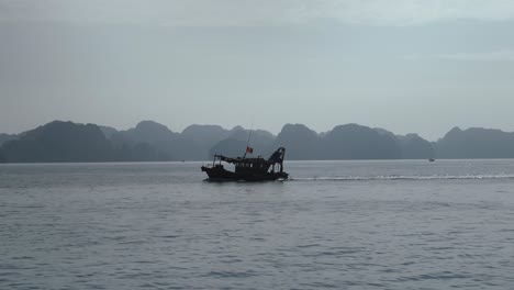 fishing boat sailing across lan ha bay in the gulf of tonkin, vietnam