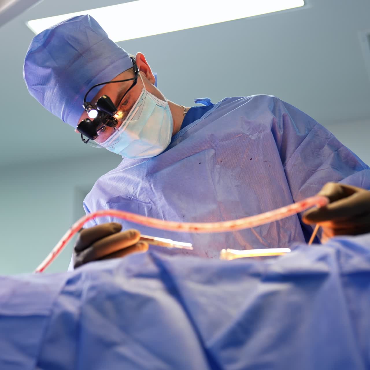 Un neurocirujano experimentado examina cuidadosamente la zona operatoria desde diferentes puntos de vista. Vista en ángulo bajo que se acerca gradualmente al doctor.