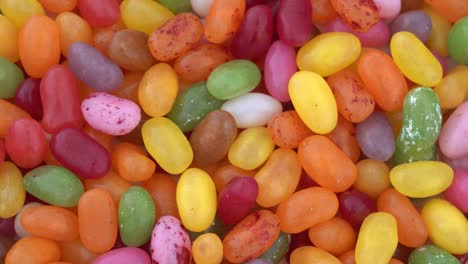 pile of small bean shaped sugar jelly candies. full frame background. rotating. view from above/overhead.