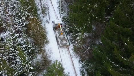 truck transporting concrete pipes in a snowy forest